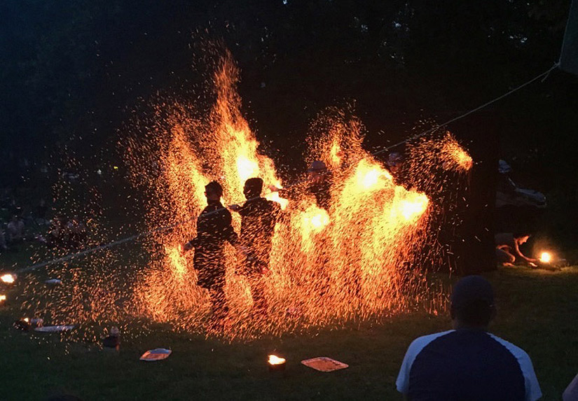 A photo of a fiery acrobatics show with sparks flying everywhere.