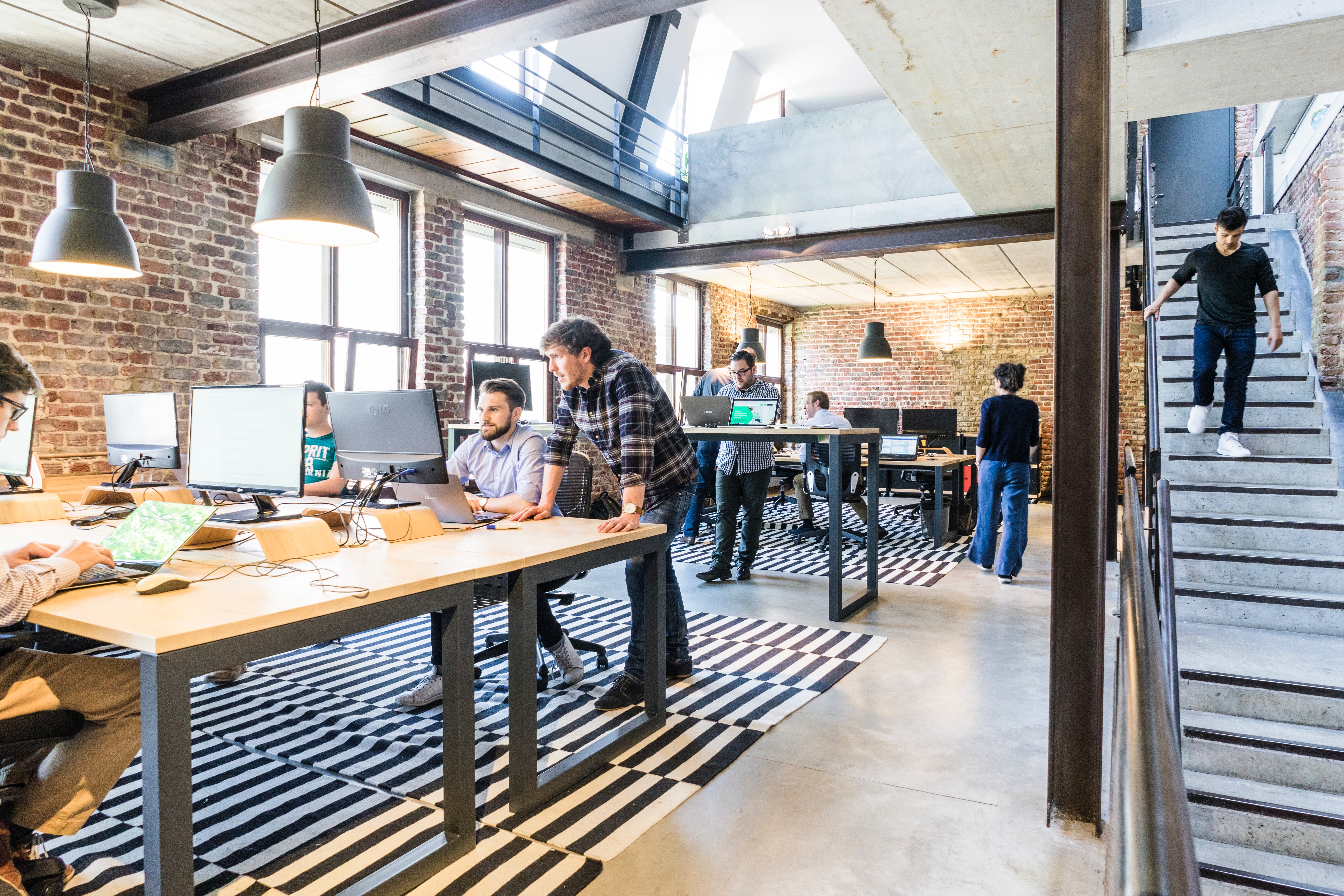 A stock photo of a startup office, with people working on various laptops.